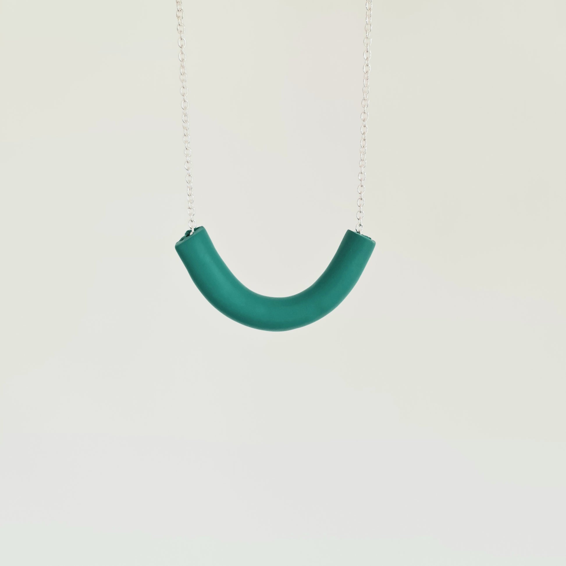 A handmade chunky green necklace on a white background